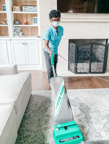 Merry Maids Team Member vacuuming a home.