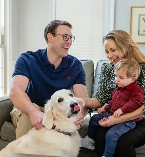 Family on couch with dog.