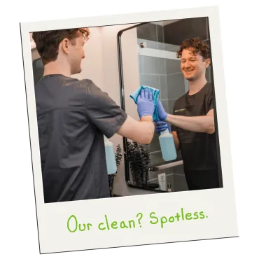 Merry Maids of Cumberland and Dauphin Counties cleaner smiling while wiping a bathroom mirror spotless